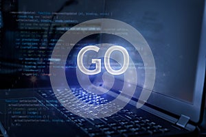 GO inscription against laptop and code background. Technology concept