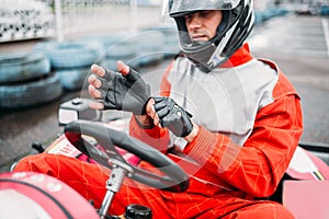 Go-kart driver in helmet on karting speed track