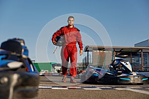 Go-kart driver walking to car before race at starting line