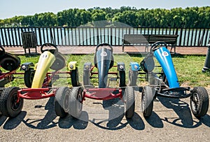 Go-karts with pedals and wheels for rent.. Many aligned colored carts