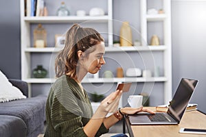 Go shopping whenever you want. a beautiful young woman using a laptop and credit card to do some online shopping at home