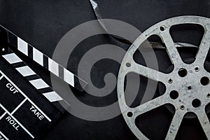 Go to the cinema with film type and clapperboard on black background top view