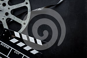 Go to the cinema with film type and clapperboard on black background top view mock up