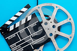 Go to the cinema with film type and clapperboard on blue background top view