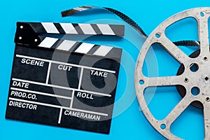 Go to the cinema with film type and clapperboard on blue background top view