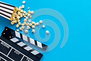 Go to the cinema with popcorn and clapperboard on blue background top view mock up