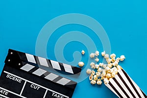 Go to the cinema with popcorn and clapperboard on blue background top view mock up