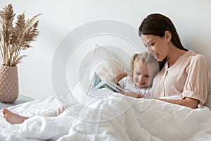 Before go to sleep mother reading to daughter fairytale