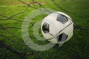 Goal concept as a soccer ball enters the gate and hits the net. Football championship background, spring outdoors tournaments.