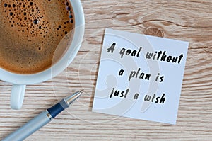 A goal without a plan is just a wish - motivational handwriting on a napkin with a cup of morning coffee