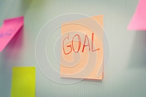 Goal. Post It. many colored sheets sticky note paper on white board background