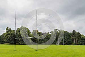 Goal posts on a rugby pitch surrounded by trees