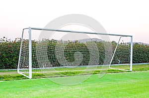 Goal shot from the corner in the front ,soccer field,empty amateur football goal posts and nets