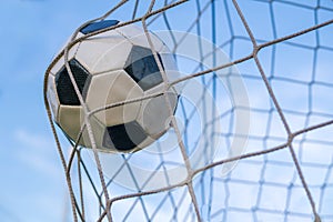 Goal - soccer or football ball in the net against blue sky