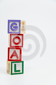 GOAL word wooden block arrange in vertical style on white background and selective focus