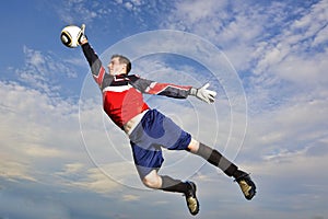 Goalie jumps to catch soccer ball photo