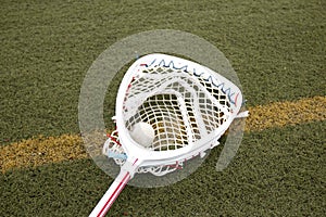 Goalies lacross stick with a ball in the net