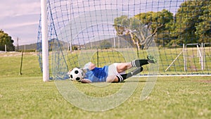 Goalkeeper in blue making a save