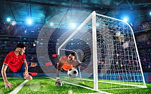 Goalkeeper catches the ball in the stadium during a football game.