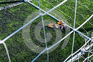 Goalkeeper gloves are on the grass near the football goal photo