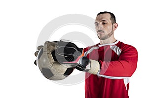 Goalkeeper holds the ball in the stadium during a football game. Isolated on white background