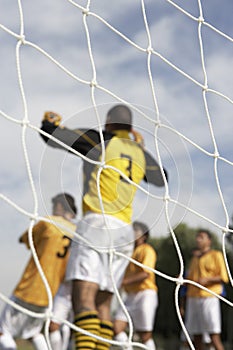 Goalkeeper jumping for soccer ball