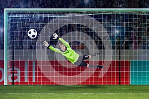 Goalkeeper kid saving in jump on a crowded stadium