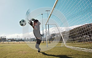 Goalkeeper, soccer and man jumping for the ball to save the goals by the score post at an outdoor field. Fitness