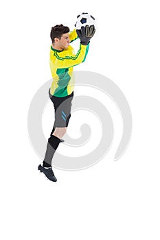 Goalkeeper in yellow making a save