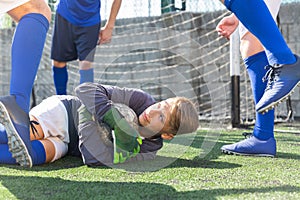 Goalkipper lying on lawn with ball in hands