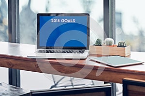 Goals for 2018 word in laptop computer screen with tablet on woo