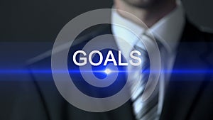 Goals, businessman wearing official suit pressing button on screen, motivation