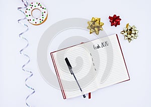 Goals for Christmas and New Year 2020. Holiday decorations in the form of a donut. Pen and notebook with wishes. Flat lay top