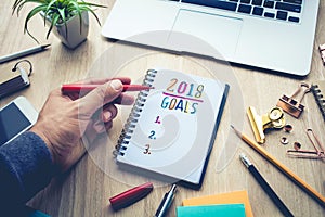 2018 GOALS concepts with male hand writing on notepad paper
