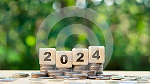 Goals and new visions for the year 2024.Wooden cubes with 2024 and target icon with coins stack. financial annual plan for money,