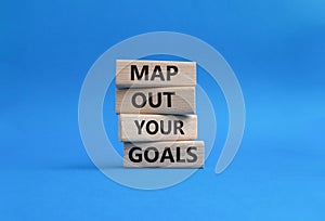Goals symbol. Wooden blocks with words Map out your goals. Beautiful blue background. Business and Map out your goals conc