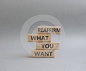Goals symbol. Wooden blocks with words Reaffirm what you want. Beautiful grey background. Business and Reaffirm what you want