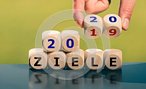 Goals for the year 2020. Hand turns dice and changes the German expression `2019 ziele` goals to `2020 Ziele`