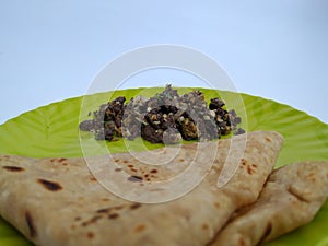 Goat Blood Fry with Eggs Combination with Chapathi or Parota in a Green Color Plate isolated on white Background