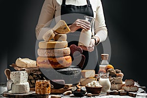 Goat cheese, Different delicious dairy products head of hard cheese in woman`s cheesemaker hands