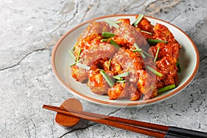 Gobi Manchurian is a popular appetizer made with fried cauliflower coated in umami chili sauce closeup on the plate. Horizontal