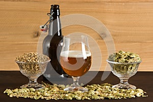 Goblet of beer, small growler, malts and hops photo