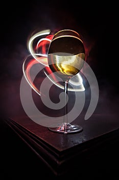 Goblet of white wine on wooden table on wooden wall background