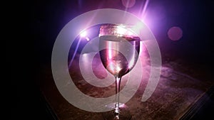 Goblet of white wine on wooden table on wooden wall background