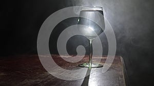 Goblet of white wine on wooden table on wooden wall background