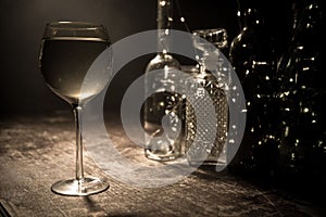 Goblet of white wine on wooden table on wooden wall background