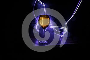 Goblet of white wine on wooden table on wooden wall background