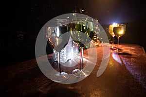 Goblet of white wine on wooden table on wooden wall background