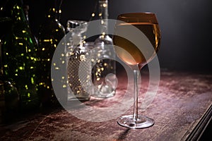 Goblet of white wine on wooden table on wooden wall background