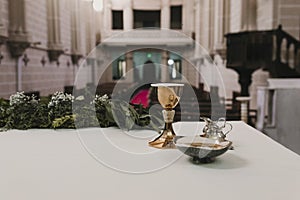 Goblet of wine on table during a wedding ceremony nuptial mass. Religion concept. Catholic eucharist ornaments for the celebration photo